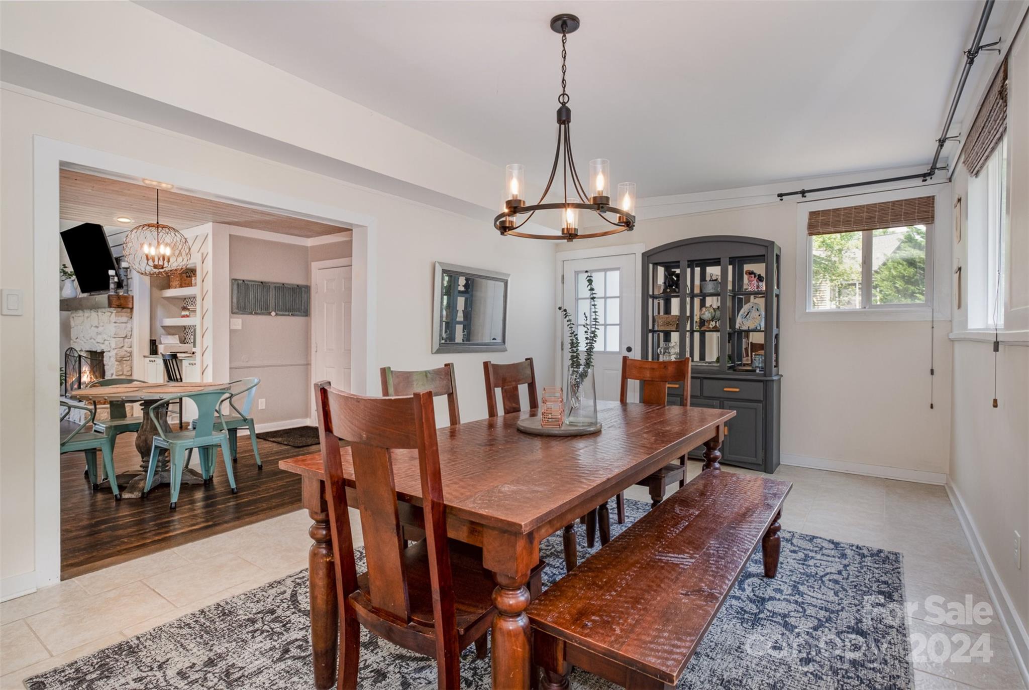4033 Windward Drive Tega Cay, SC 29708 - Photo 11 of 38 a view of a dining room and livingroom with furniture wooden floor a rug a potted plant and a chandelier