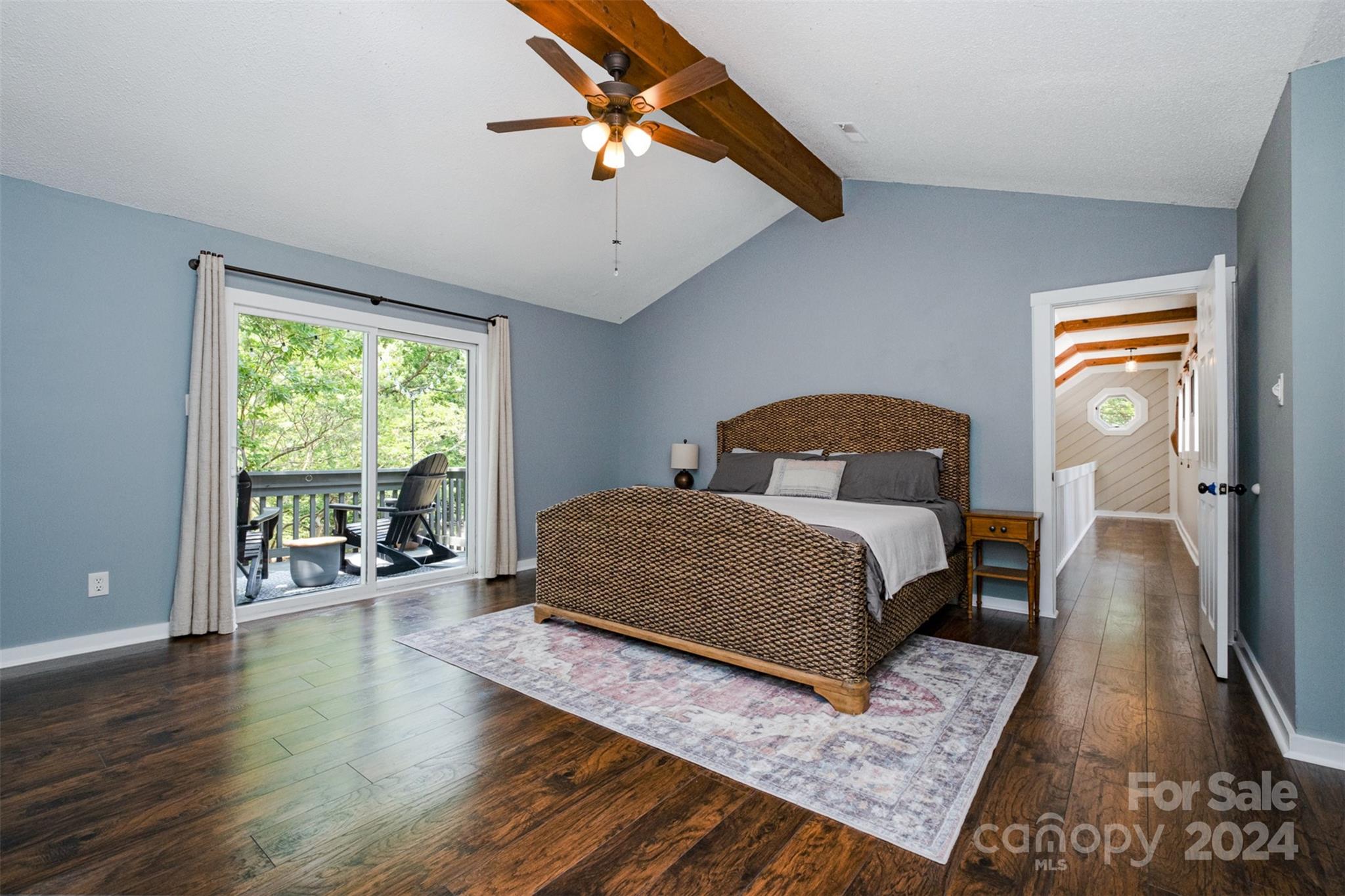 4033 Windward Drive Tega Cay, SC 29708 - Photo 19 of 38 a bedroom with a bed a table and three large window with wooden floor