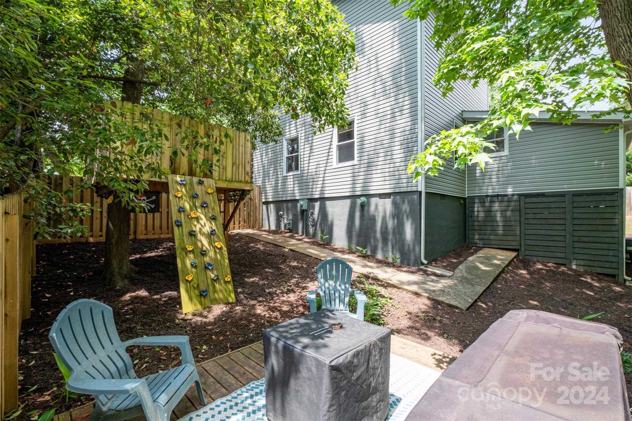 4033 Windward Drive Tega Cay, SC 29708 - Photo 36 of 38 a view of a patio with table and chairs potted plants and large tree