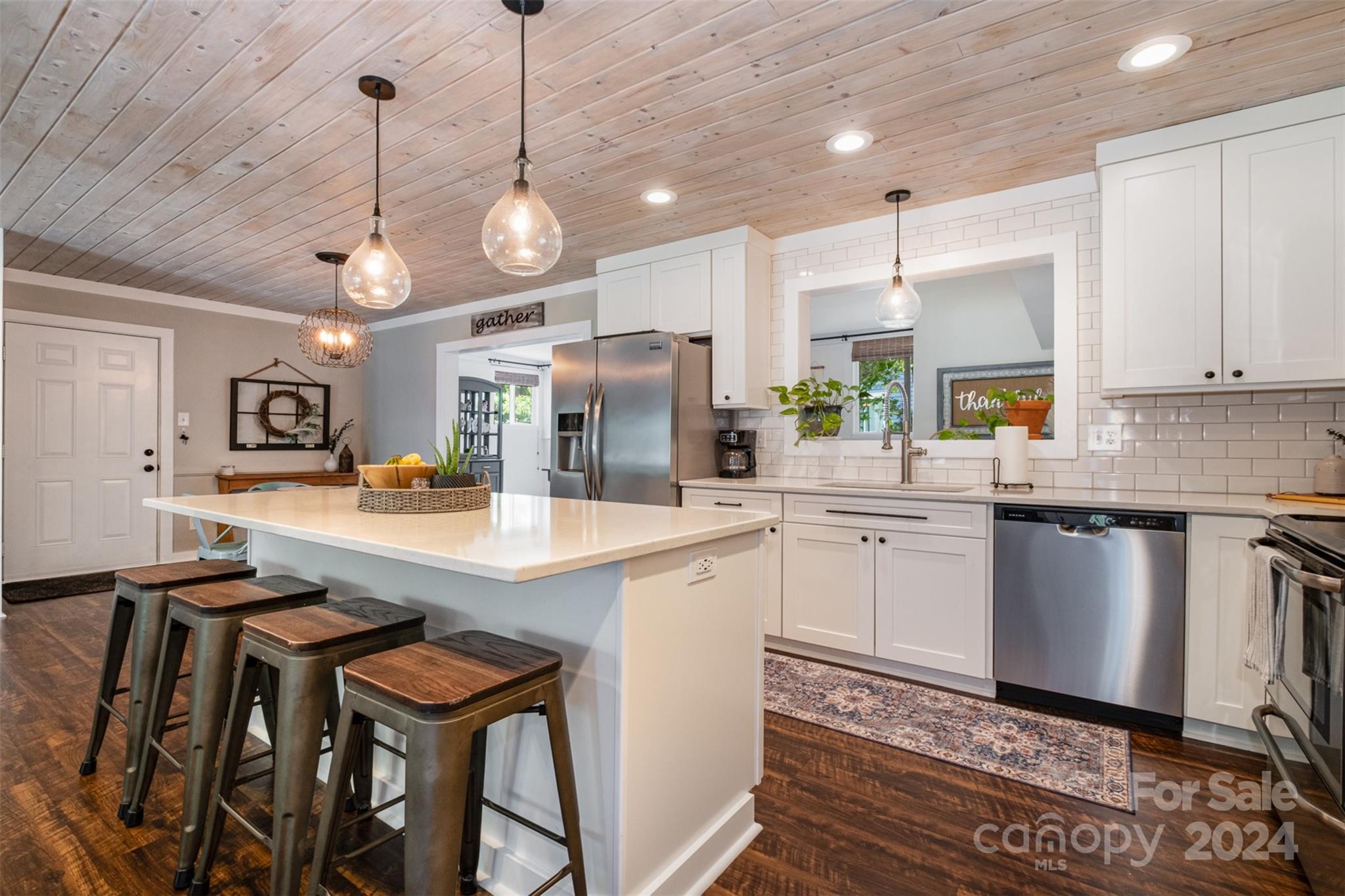 4033 Windward Drive Tega Cay, SC 29708 - Photo 6 of 38 a kitchen with stainless steel appliances granite countertop a sink a stove a refrigerator cabinets and chairs