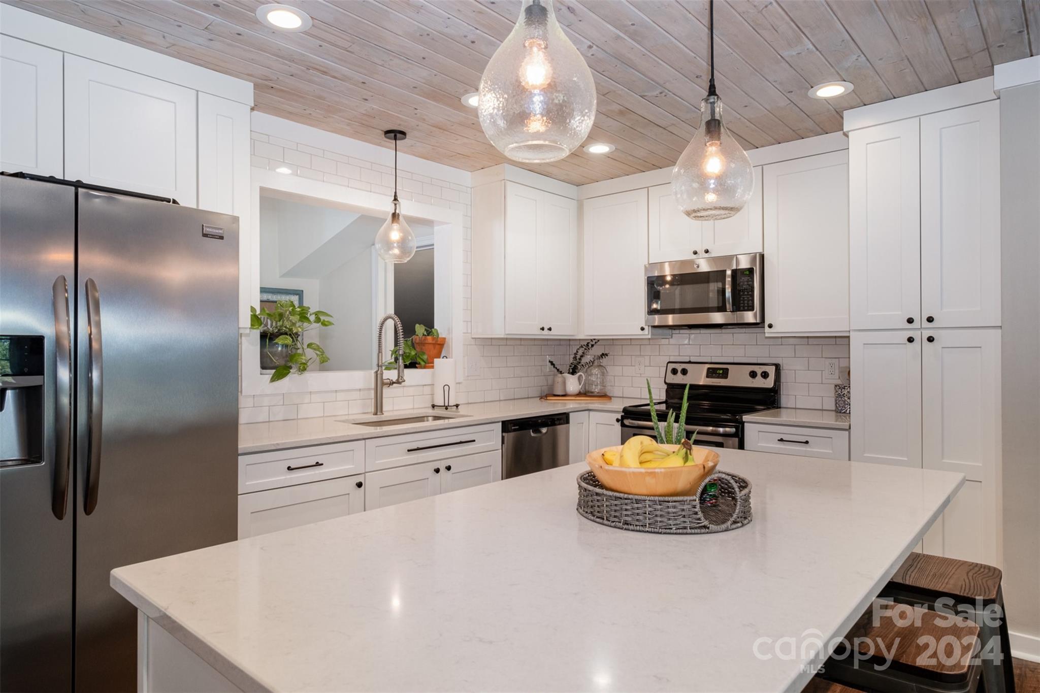 4033 Windward Drive Tega Cay, SC 29708 - Photo 8 of 38 a kitchen with kitchen island a stove a sink and a refrigerator