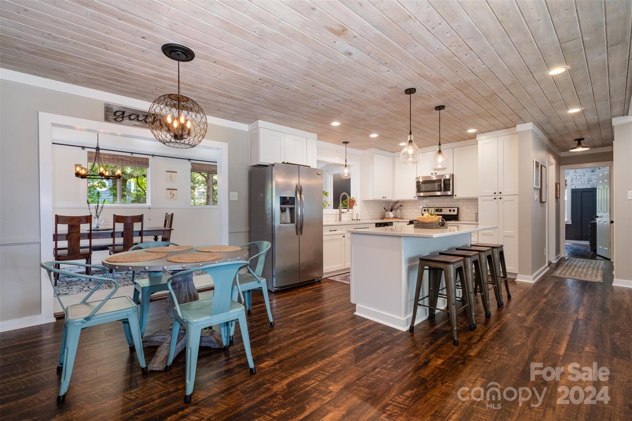 4033 Windward Drive Tega Cay, SC 29708 - Photo 10 of 38 a kitchen with stainless steel appliances kitchen island granite countertop a dining table chairs refrigerator and sink