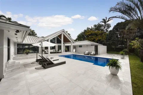 a view of a house with swimming pool and sitting area
