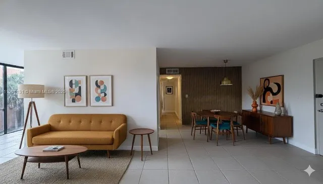 a living room with furniture and a dining table with chair