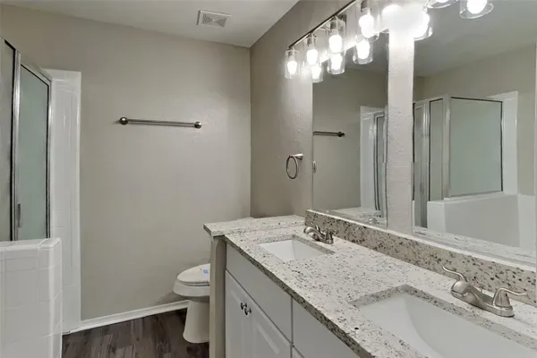 a bathroom with a granite countertop sink toilet and shower