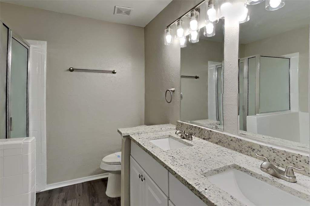 4013 David Circle Rowlett, TX 75088 - Photo 11 of 19 a bathroom with a granite countertop sink toilet and shower