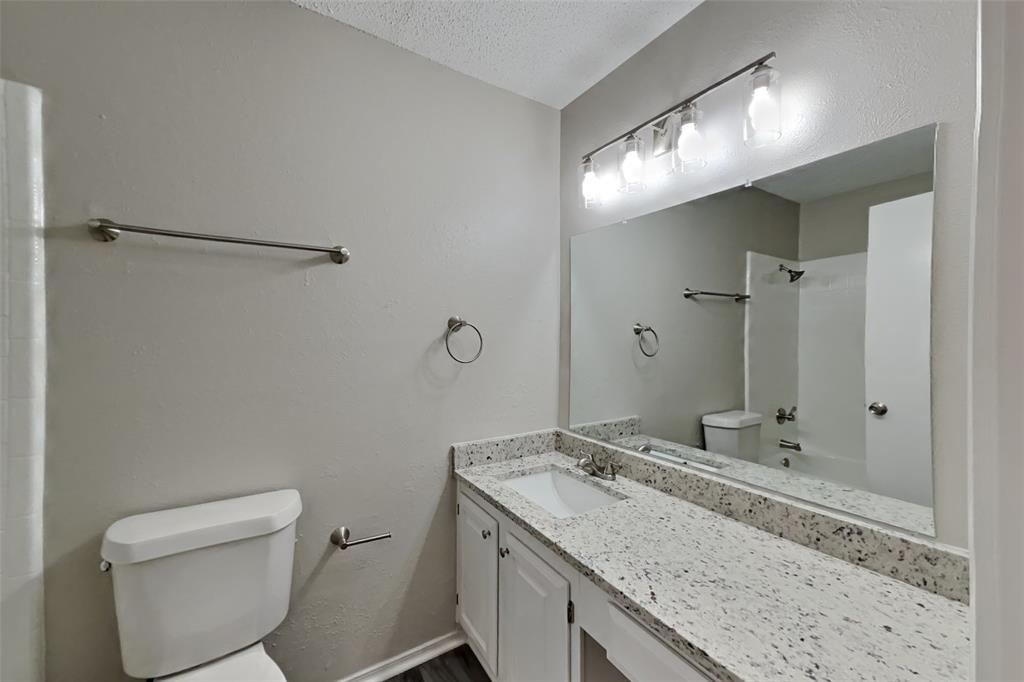 4013 David Circle Rowlett, TX 75088 - Photo 17 of 19 a bathroom with a granite countertop sink toilet and shower