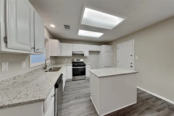 a kitchen with a sink stove and cabinets