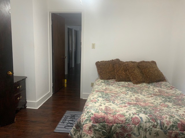 850 Slade Street Coldspring, TX 77331 - Photo 15 of 31 a bedroom with a bed and wooden floor