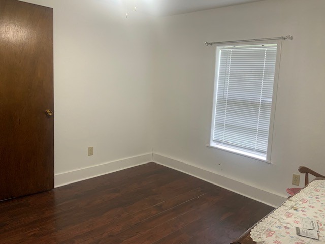 850 Slade Street Coldspring, TX 77331 - Photo 25 of 31 a view of a bedroom with wooden floor and a window