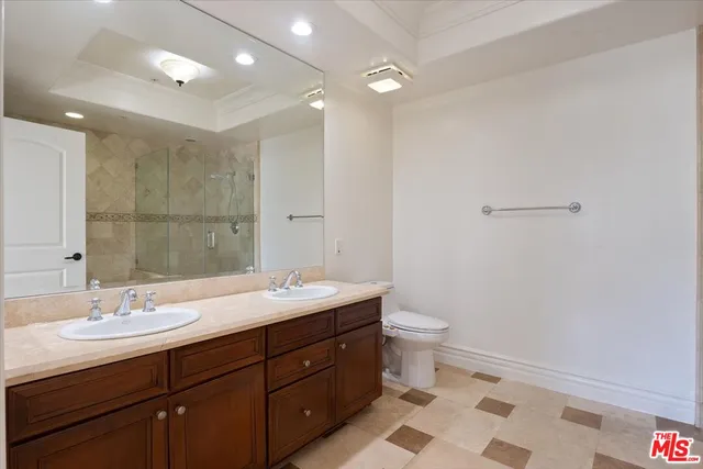 a bathroom with a granite countertop sink a toilet and a mirror