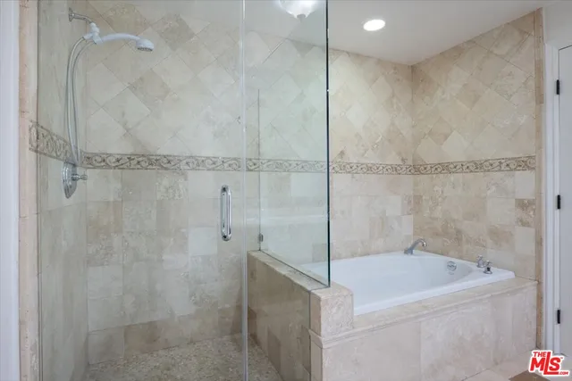 a view of a hallway with wooden floor and a bathroom