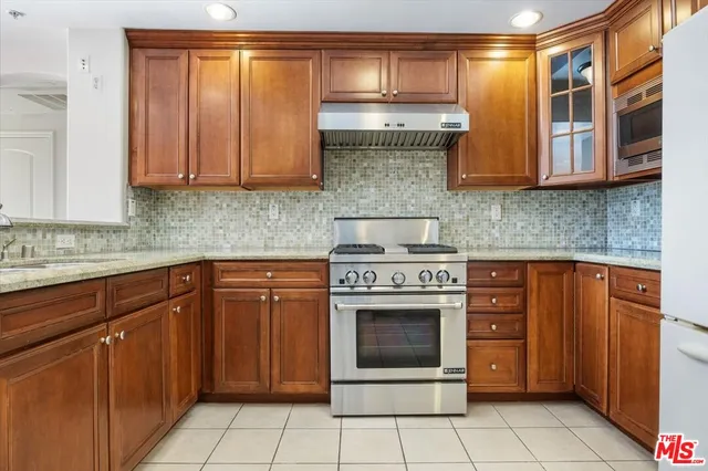 a kitchen with stainless steel appliances granite countertop a stove and a microwave