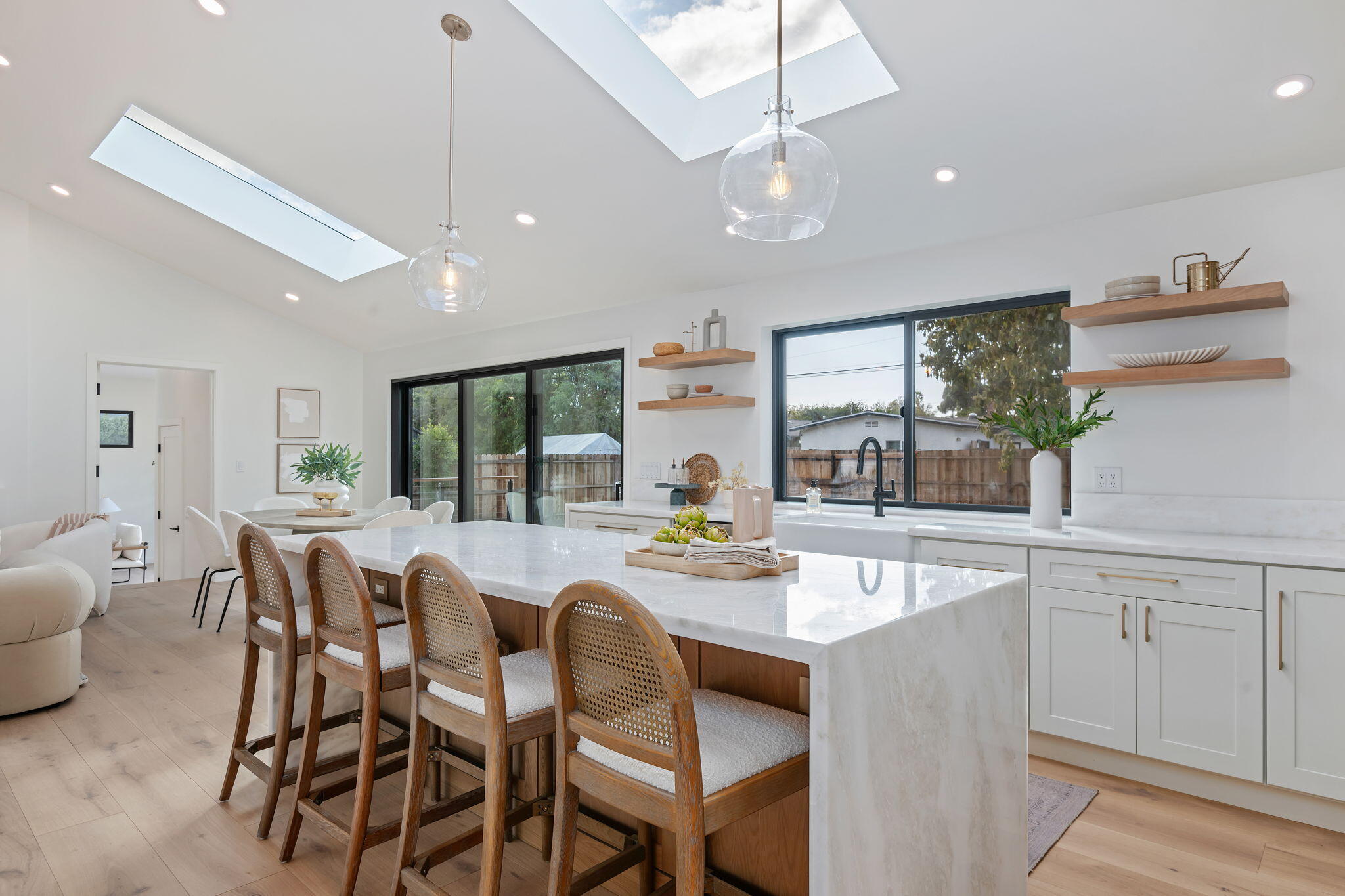 a dining room with stainless steel appliances furniture large window and wooden floor