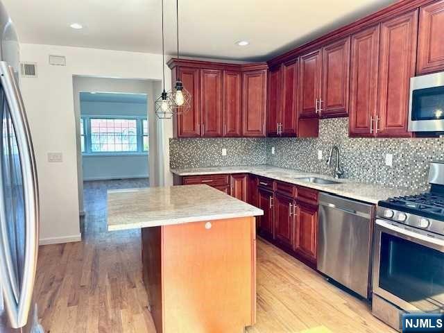 1249 Beaumont Avenue Teaneck, NJ 07666 - Photo 12 of 23 a kitchen with stainless steel appliances granite countertop wooden cabinets a sink and dishwasher