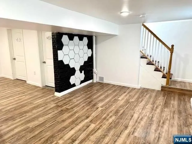 a view of a bedroom with wooden floor and stairs