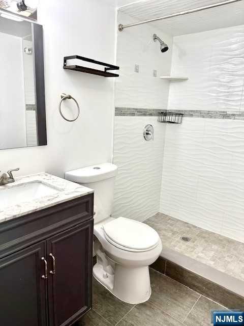 1249 Beaumont Avenue Teaneck, NJ 07666 - Photo 19 of 23 a bathroom with a granite countertop sink toilet and shower