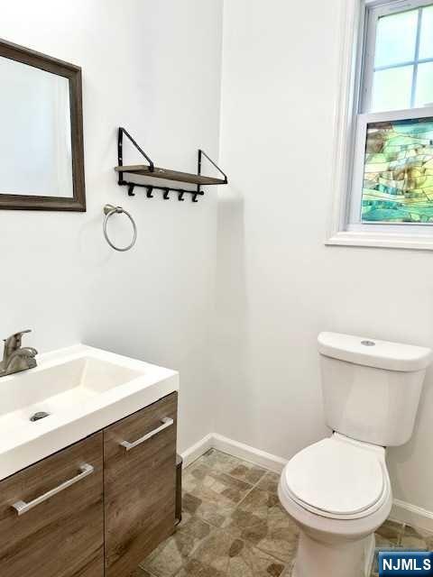 1249 Beaumont Avenue Teaneck, NJ 07666 - Photo 8 of 23 a bathroom with a sink mirror vanity and toilet