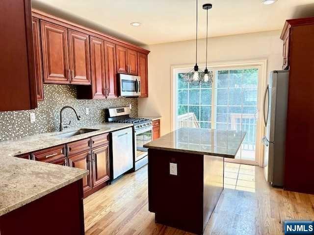 1249 Beaumont Avenue Teaneck, NJ 07666 - Photo 10 of 23 a kitchen with stainless steel appliances granite countertop wooden cabinets a sink dishwasher a stove and a refrigerator with wooden floor