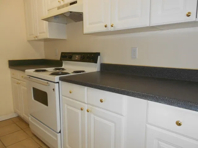 a white stove top oven sitting inside of a kitchen