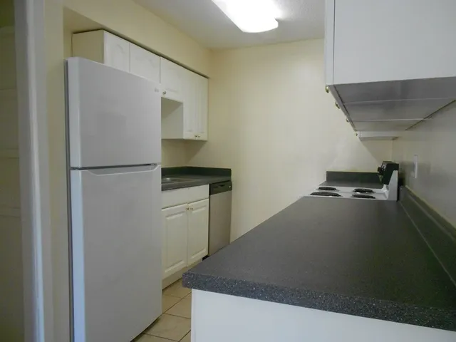 a kitchen with a refrigerator and a stove