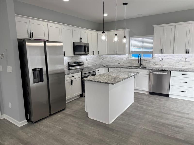 1202 Pisgah Road Southwest Austell, GA 30168 - Photo 25 of 30 a kitchen with stainless steel appliances granite countertop a stove a sink a refrigerator a center island and cabinets