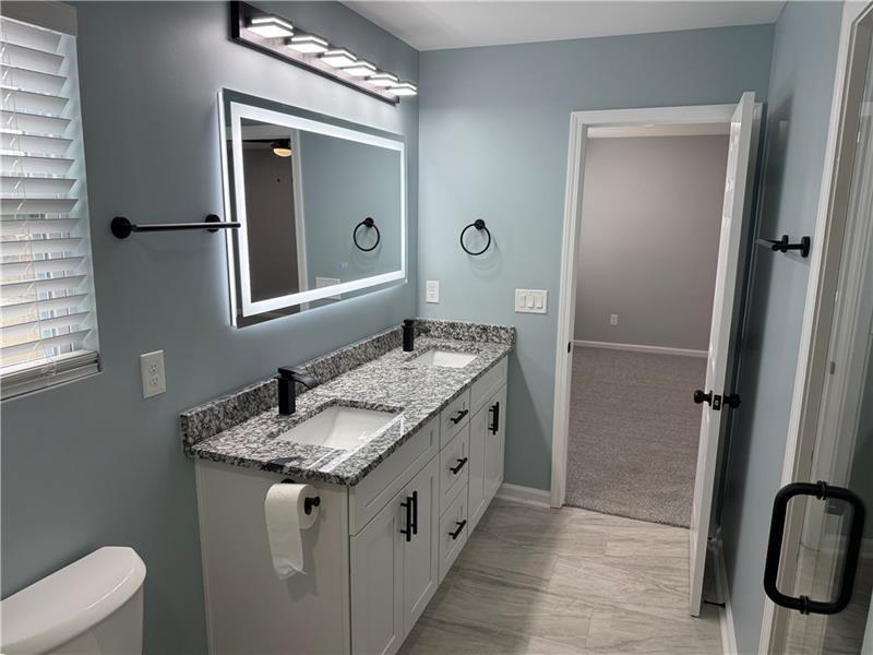 1202 Pisgah Road Southwest Austell, GA 30168 - Photo 3 of 30 a bathroom with a granite countertop sink and a mirror