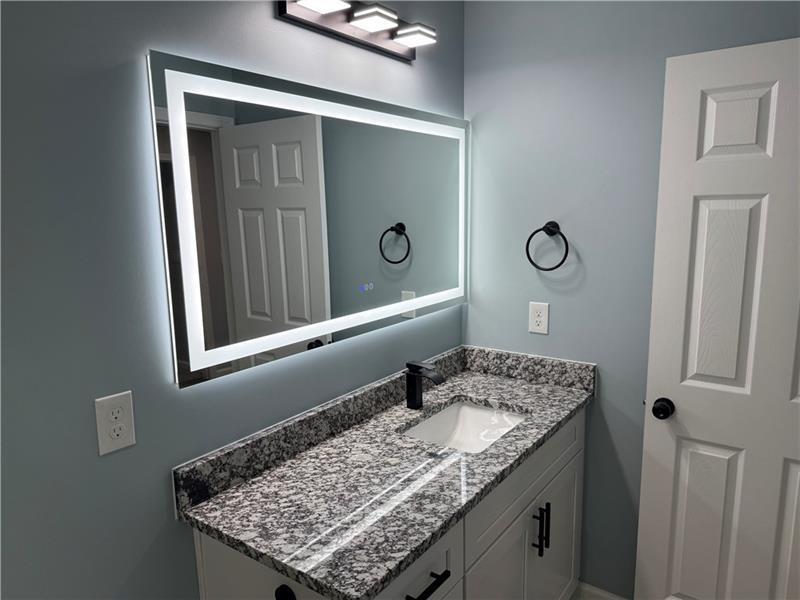 1202 Pisgah Road Southwest Austell, GA 30168 - Photo 7 of 30 a bathroom with a granite countertop sink and a mirror