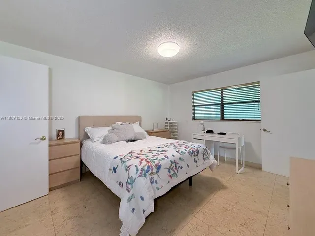 a bedroom with a bed table and window