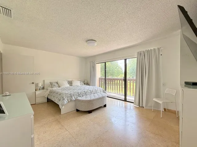 a spacious bedroom with a bed and a large window