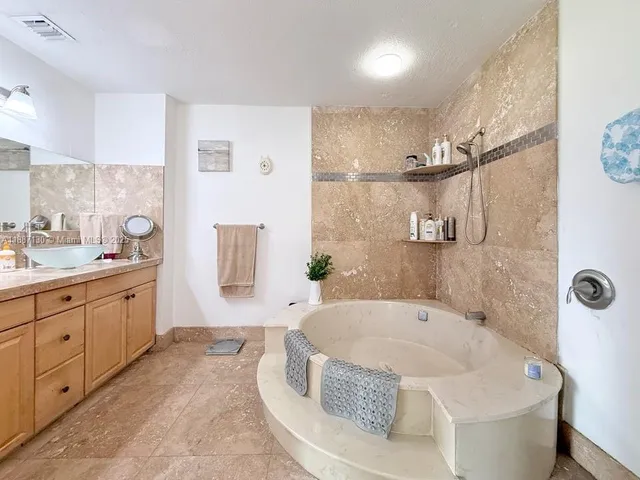 a spacious bathroom with a tub sink and mirror