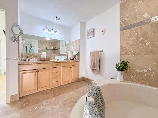 a spacious bathroom with a double vanity sink a mirror a shower and a bathtub