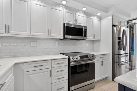 a kitchen with white cabinets and stainless steel appliances