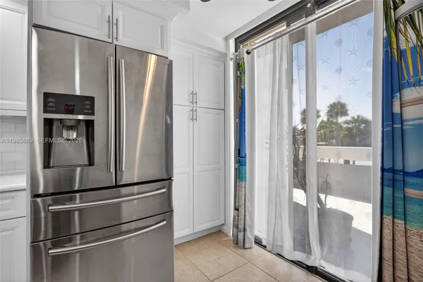 a metallic refrigerator freezer sitting inside of a kitchen
