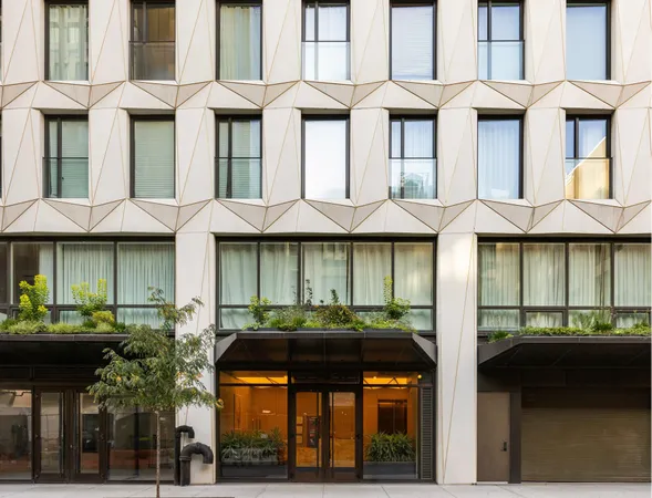 a front view of a building with lots of windows and plants