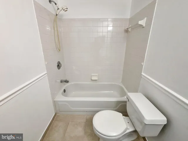 a white toilet and tub next to a shower
