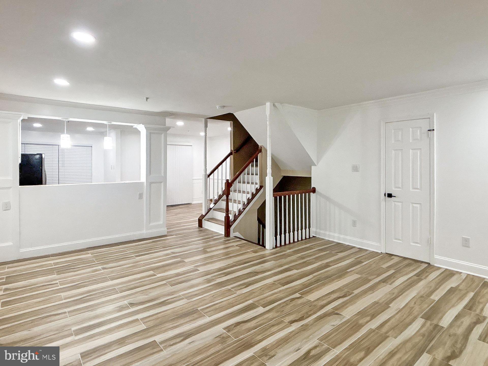 3558 Corn Stream Road Randallstown, MD 21133 - Photo 2 of 28 a view of an empty room with wooden floor and stairs