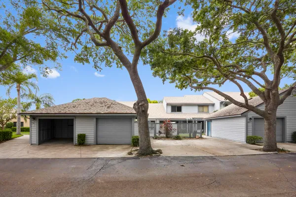 a view of a house with a tree and a yard