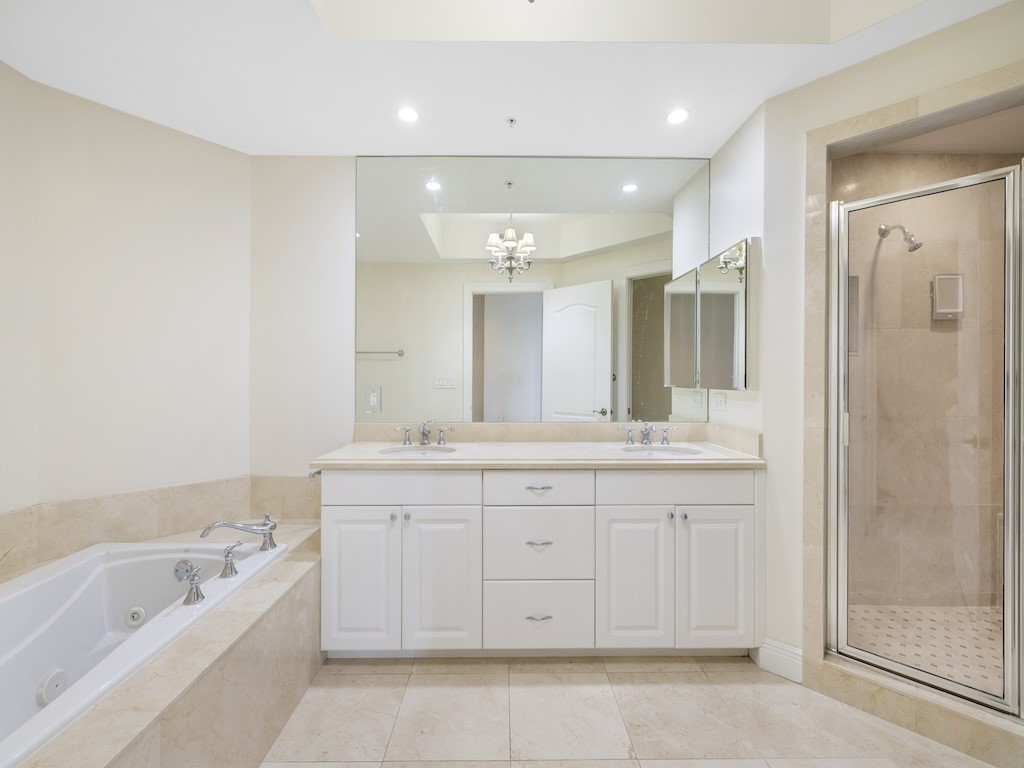 9013 Somerset Bay Lane, Unit 201 Vero Beach, FL 32963 - Photo 12 of 27 a spacious bathroom with a granite countertop sink a toilet a mirror and bathtub