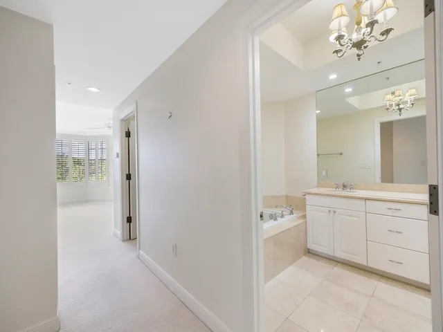 a spacious bathroom with a granite countertop sink a mirror and a bathtub
