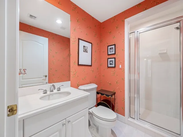 a bathroom with a sink a toilet a mirror and shower