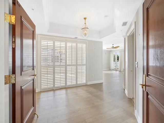a view of empty room with wooden floor and fan
