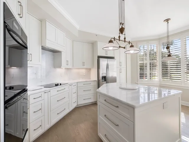 a kitchen with cabinets stainless steel appliances a sink and a window