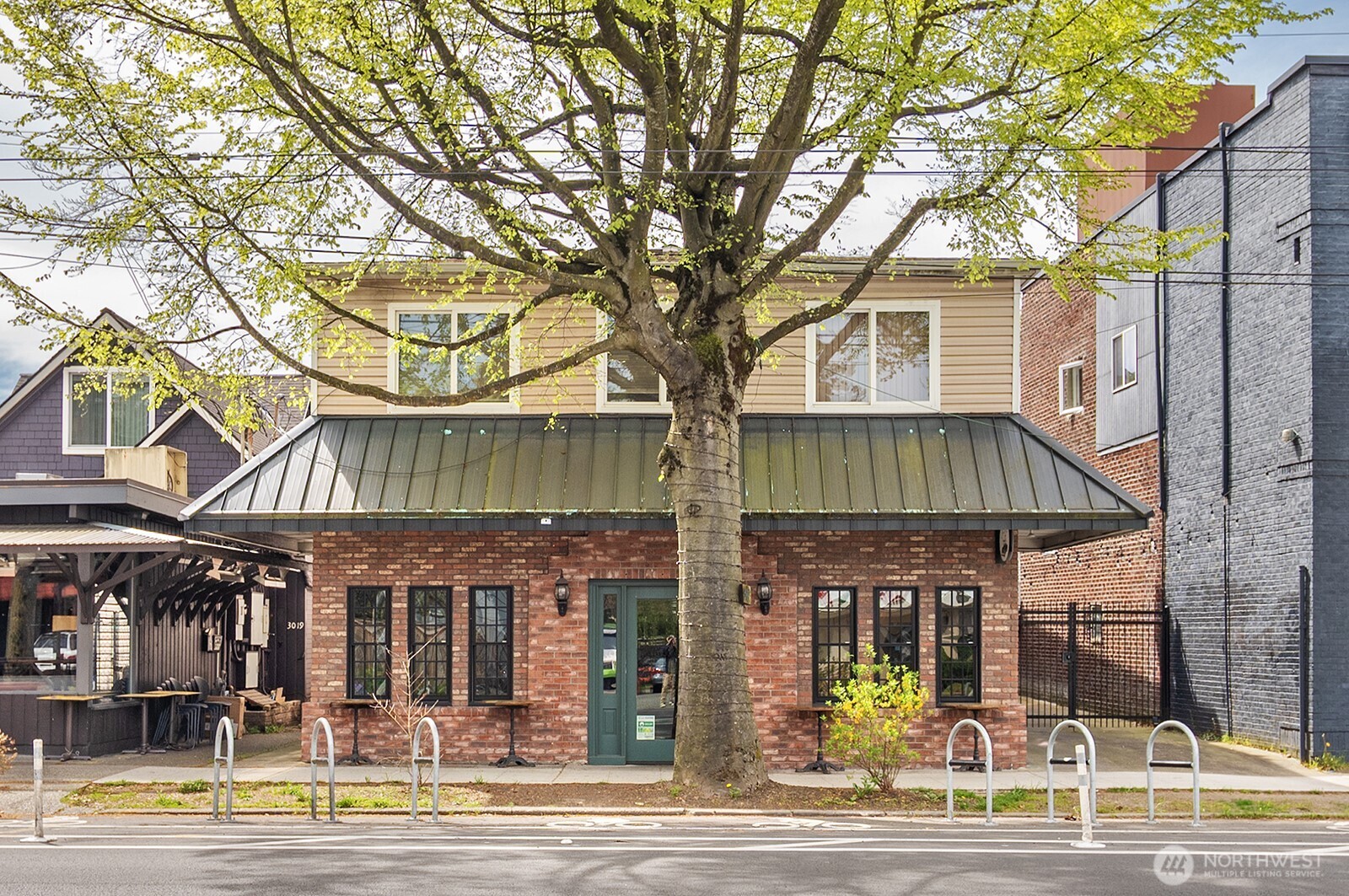 a view of a large building with a white walls and a large tree