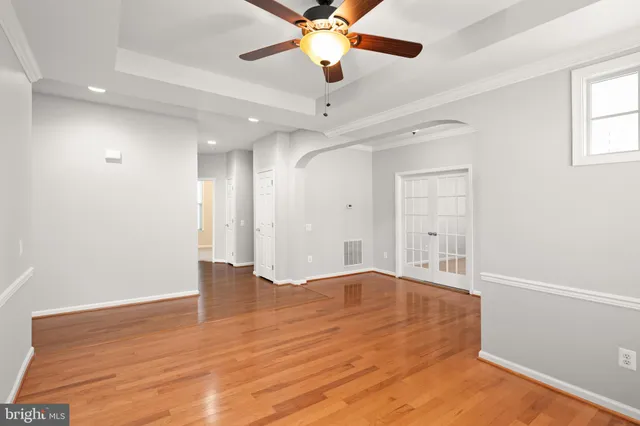an empty room with windows and fan
