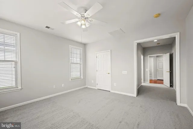 an empty room with chandelier fan