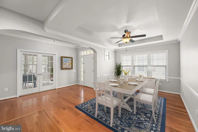a living room with furniture kitchen view and a wooden floor