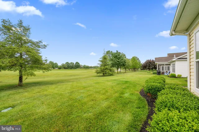a front view of a house with a garden and trees
