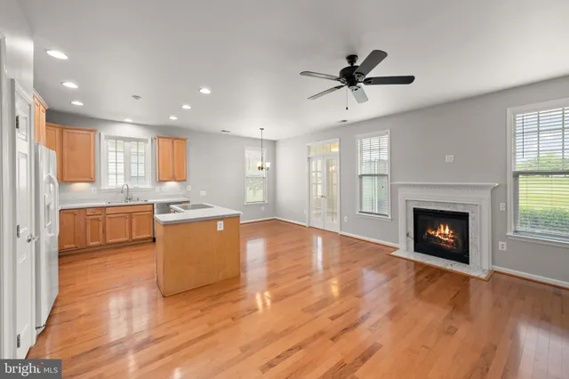 a view of an empty room with wooden floor and a fireplace