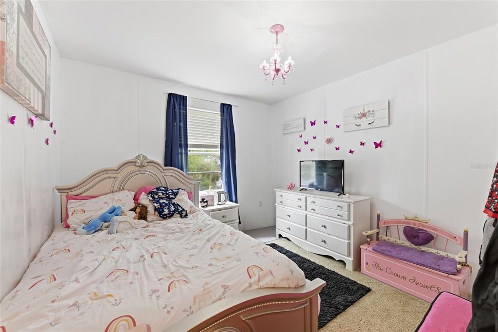 725 Cypress Road St. Augustine, FL 32086 - Photo 22 of 29 a bedroom with a bed and a chandelier